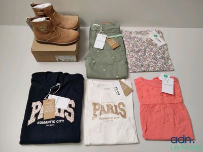 several pairs of shoes, t - shirts, and a pair of boots are sitting on a table