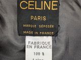 the label on the back of a grey dress with a gold chain