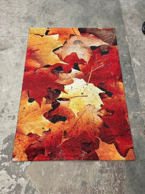 a close up of a rug with leaves on it