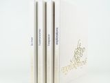 three books are stacked on top of each other on a white surface