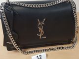 a black saint laurent handbag with a chain strap on a table