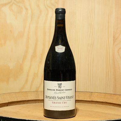 a bottle of wine sitting on top of a wooden barrel