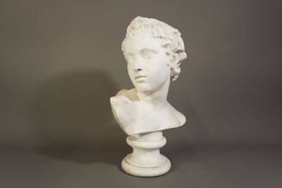 buste en marbre blanc représentant une femme aux cheveux bouclés, posé sur un socle