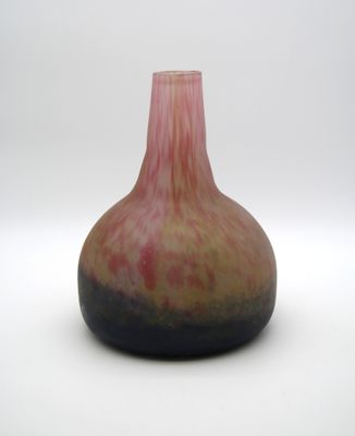 un vase rose et noir posé sur une surface blanche