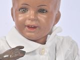a baby doll with a bald head and a white shirt