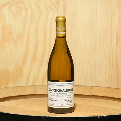 a bottle of wine sitting on top of a barrel