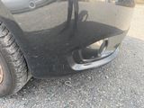 un gros plan sur le pare-chocs avant et le pneu d'une voiture