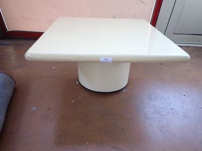 une table blanche posée à même le sol devant une porte