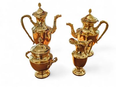 two gold teapots and a coffee pot on a white background