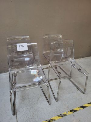 deux chaises transparentes posées l'une à côté de l'autre sur le sol