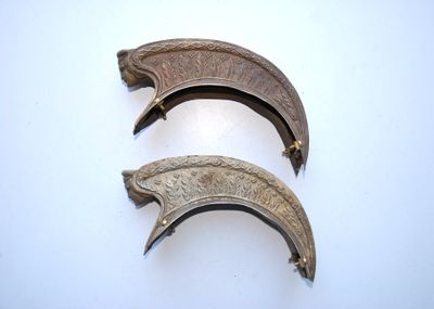 two pieces of metal on a white surface