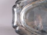 a silver tray with a silver handle on a table