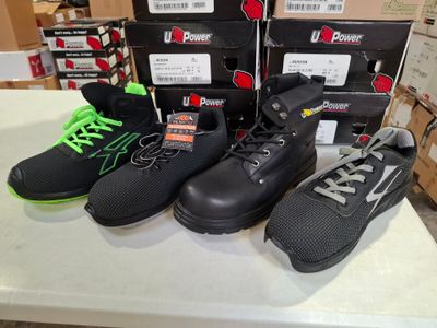five pairs of shoes on a table with boxes in the background
