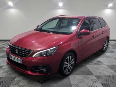a red car is parked in a room with a checkered floor