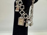 silver bracelet with charms on a black mannequin hand
