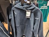 a rack of clothing in a store with a hat on it