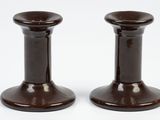 two brown candlesticks sitting on a white surface