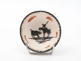 a black and white plate with a picture of a man on a horse