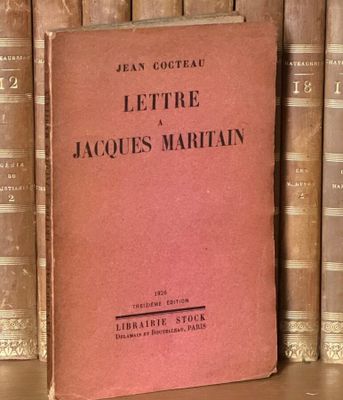 un livre posé sur une étagère, devant une pile de livres