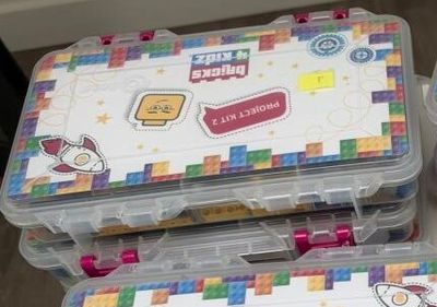 a lot of legos in the plastic containers on the table