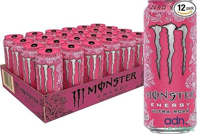 une boisson énergisante « Monster » rose dans une boîte en carton, à côté d'un carton de canettes