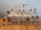 bottles and glasses are lined up on a wooden crate on a table