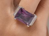 une image montrant un gros plan de la main d'une personne portant une bague sertie d'une pierre violette
