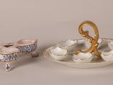 a small plate with a small bowl and a small bowl on it