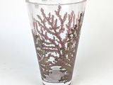 a glass vase with a design on it sitting on a table