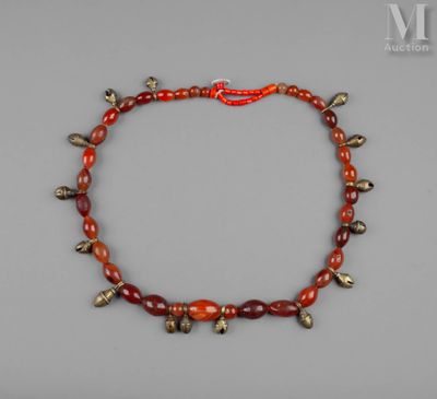 un collier de perles rouges et dorées orné de clochettes