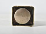 an image of a small square metal object on a white surface