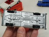 a person holding a silver toy car in their hand