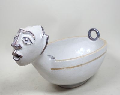 un bol blanc sur lequel est dessiné un visage sur le côté