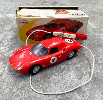 une petite voiture rouge reliée à un cordon blanc