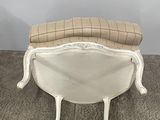 beige and white upholstered chair on carpeted area with wall in background