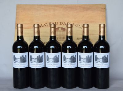 six bouteilles de vin rouge sont alignées devant une caisse en bois