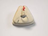 a small white object with a red string on it