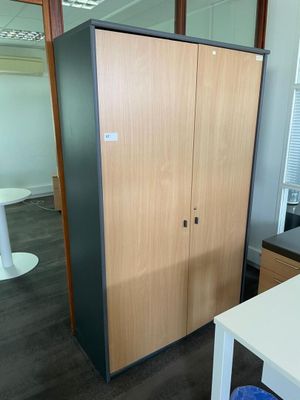 a cabinet in the middle of a room with a blue stool