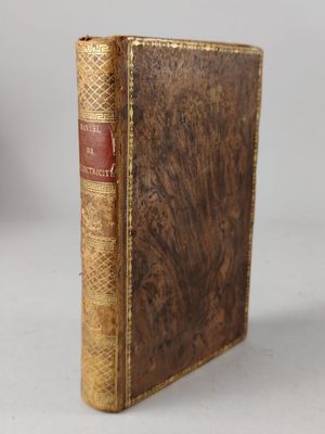 an old book sitting on top of a table next to a white wall