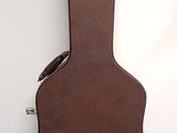 an image of a brown guitar case sitting on top of a white wall