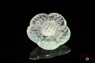 a glass flower that is sitting on a black surface