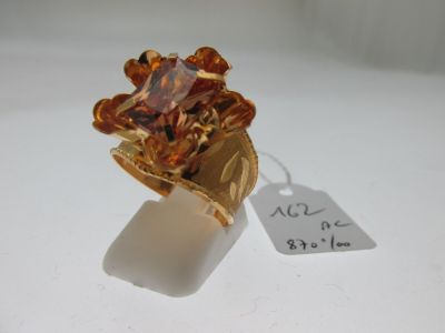 une image représentant une bague en or sertie d'une pierre marron