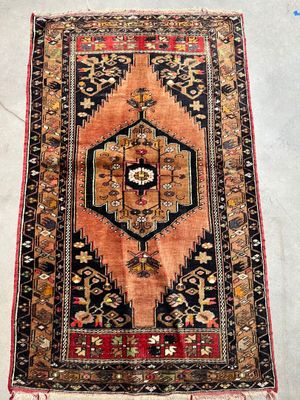 an antique persian rug with a geometric design and fringe fringes