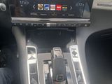 someone is sitting in the driver ' s seat of a car with a cell phone in the center console