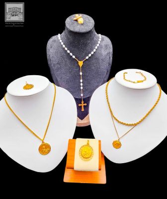 trois colliers et un collier avec une croix sur un support