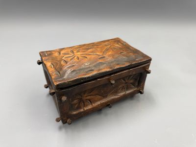 une vieille boîte en bois posée sur une surface blanche