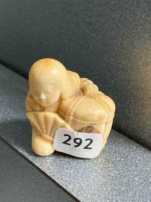 une petite figurine posée sur une étagère, avec une étiquette de prix