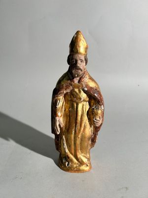 une image représentant une figurine d'un homme portant un chapeau et une robe
