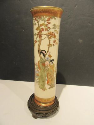 a vase with a painting on it sitting on a table