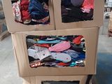 un chariot en carton sur lequel sont empilés des vêtements